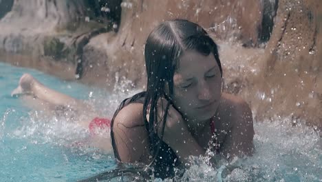 lady-rests-under-artificial-waterfall-and-straightens-hair