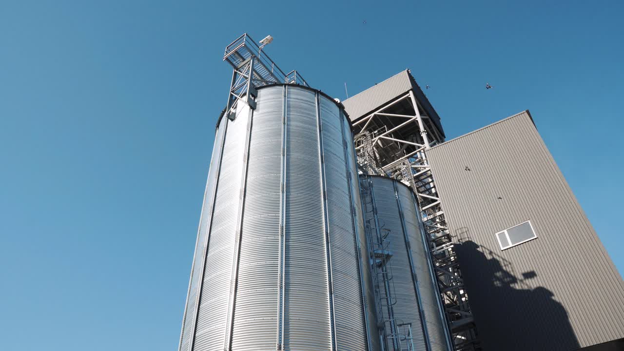 Big metallic silver containersp. Agricultural silos. Storage and drying of grains, wheat, corn, soy, sunflower. Industrial building exterior