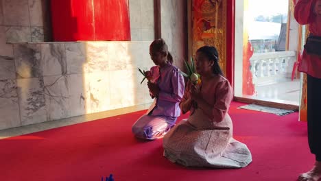 mujeres tailandesas orando en un templo
