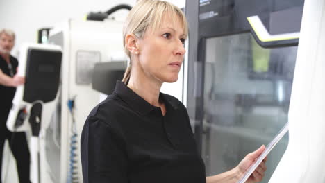 Female-Engineer-Operating-CNC-Machinery-On-Factory-Floor