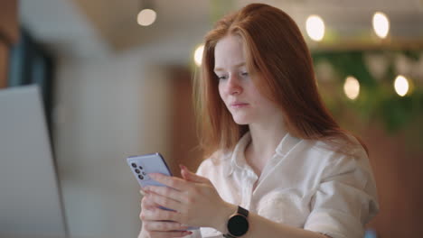 female office worker is using mobile phone during working day sending message and viewing social media