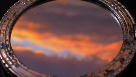 reflective lens capturing the beauty of a dramatic sky at sunset, showcasing vibrant hues and atmospheric conditions in a stunning display of colors