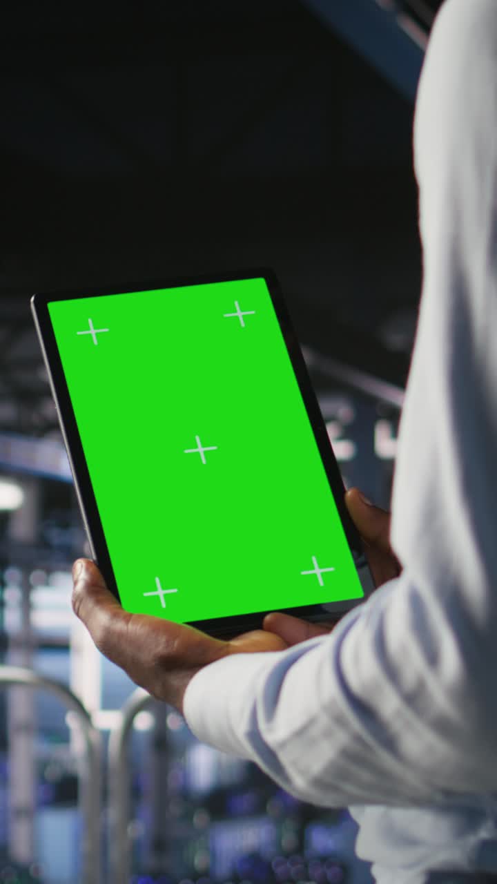 Vertical video Data center engineers on industrial platform using isolated screen device