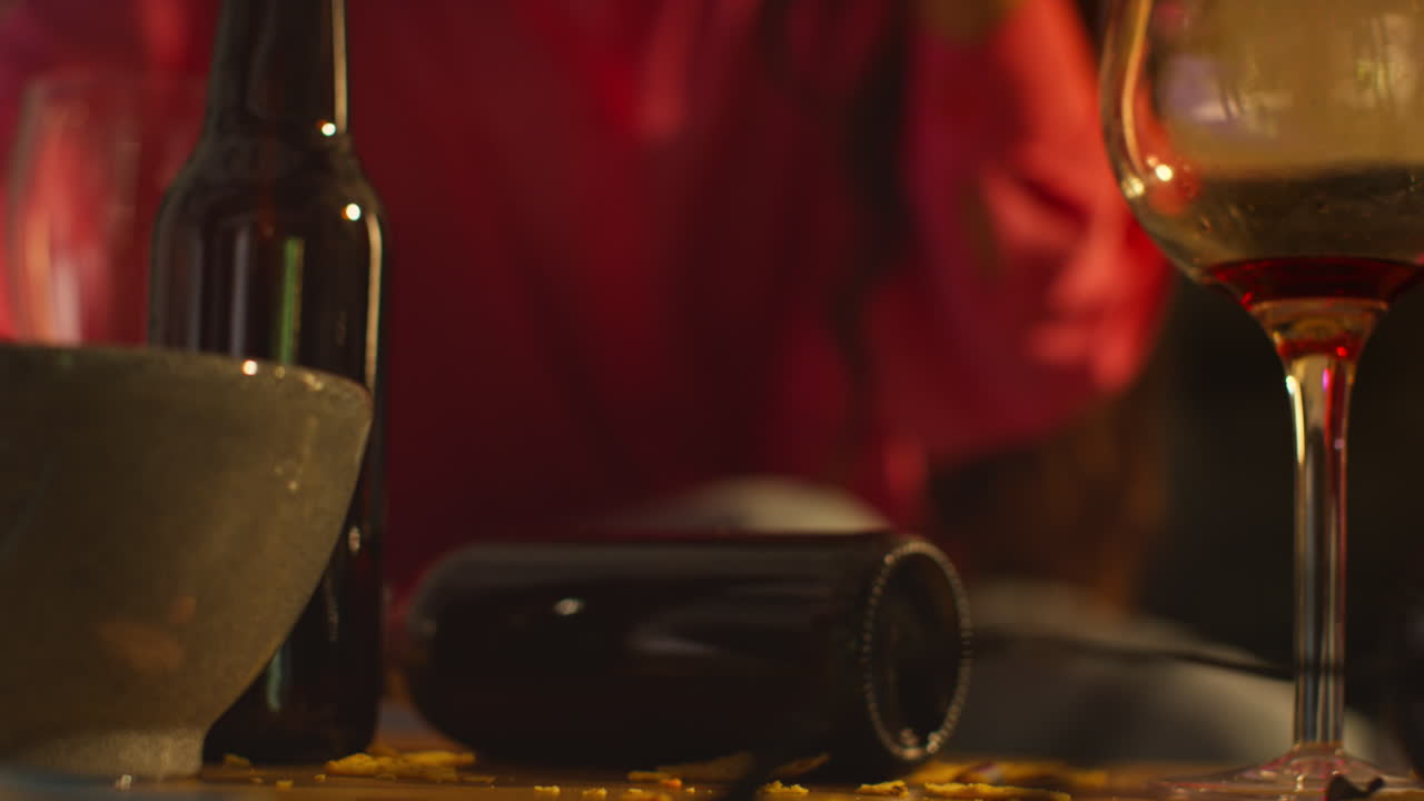 un primer plano de una mujer sentada en el sofá después de beber alcohol en una fiesta de la casa alcanzando un vaso de agua para la resaca