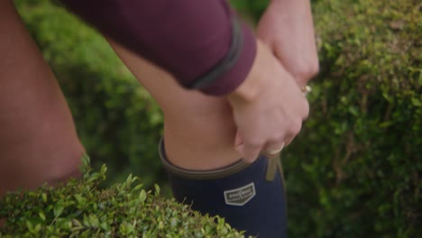 person putting boots on in garden