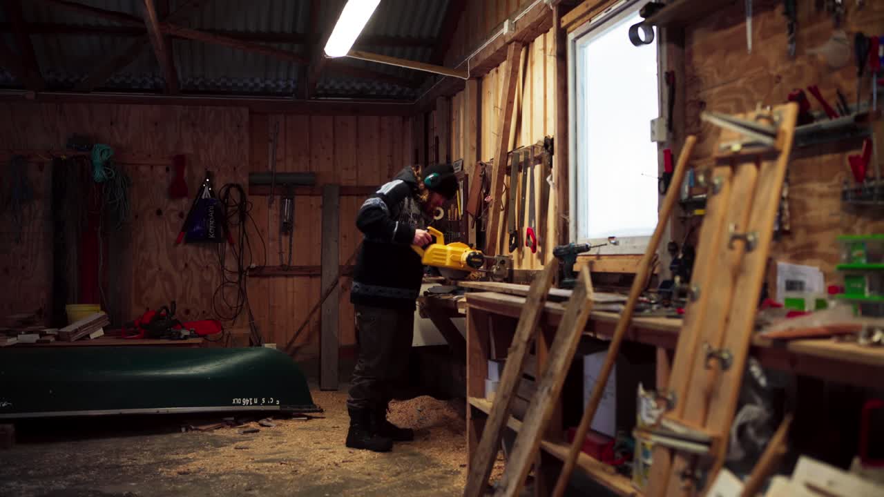 человек, использующий круговую пилу, чтобы разрезать кусок древесины в индере фосен, округ тронделаг, норвегия - статический кадр