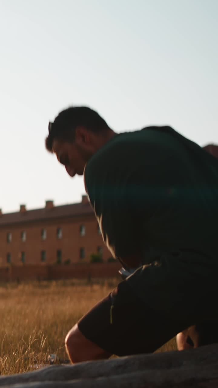 A man walking in a field with a building in the background