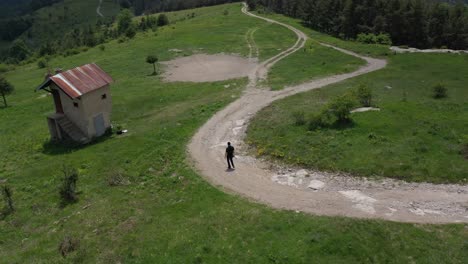 Toma-Orbital-De-Un-Hombre-Caminando-Por-Un-Sendero-De-Montaña-En-La-Montaña-Ródope,-Bulgaria