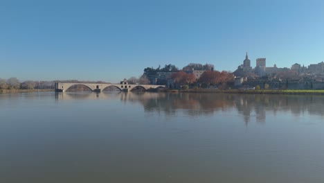 aerial establishing shot of pont st-bénézet with palais des papes behind