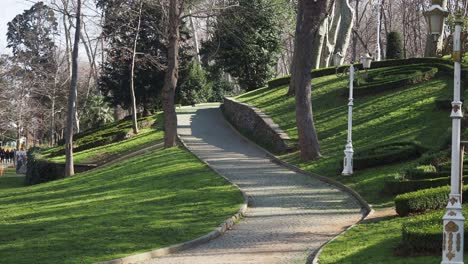 a winding stone path leads through a lush green park