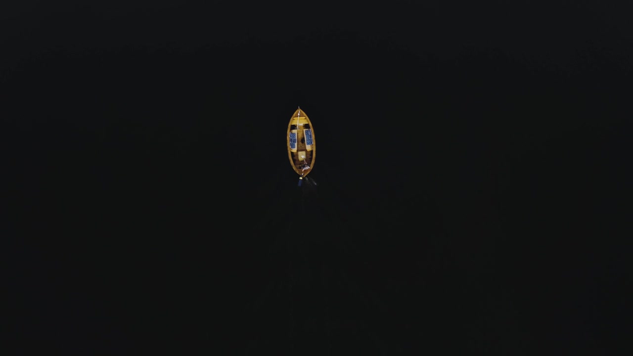 Over the top view aerial shot of old wooden boat driving on lake