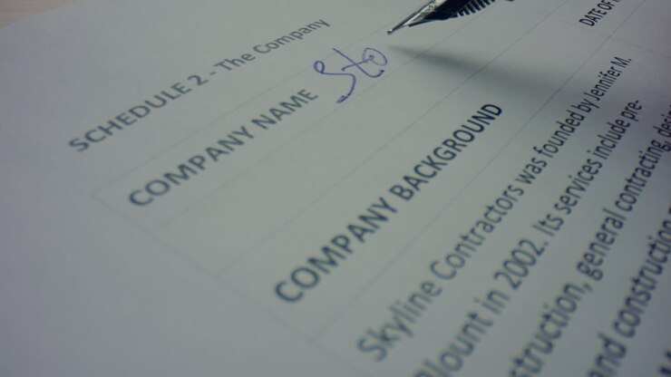 Lavoratore che compila documenti commerciali con una penna stilografica. Persona che prende appunti su un contratto.