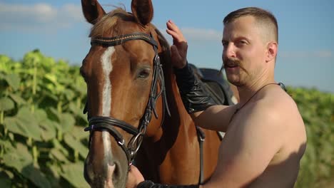 man stroking a horse on the field 02