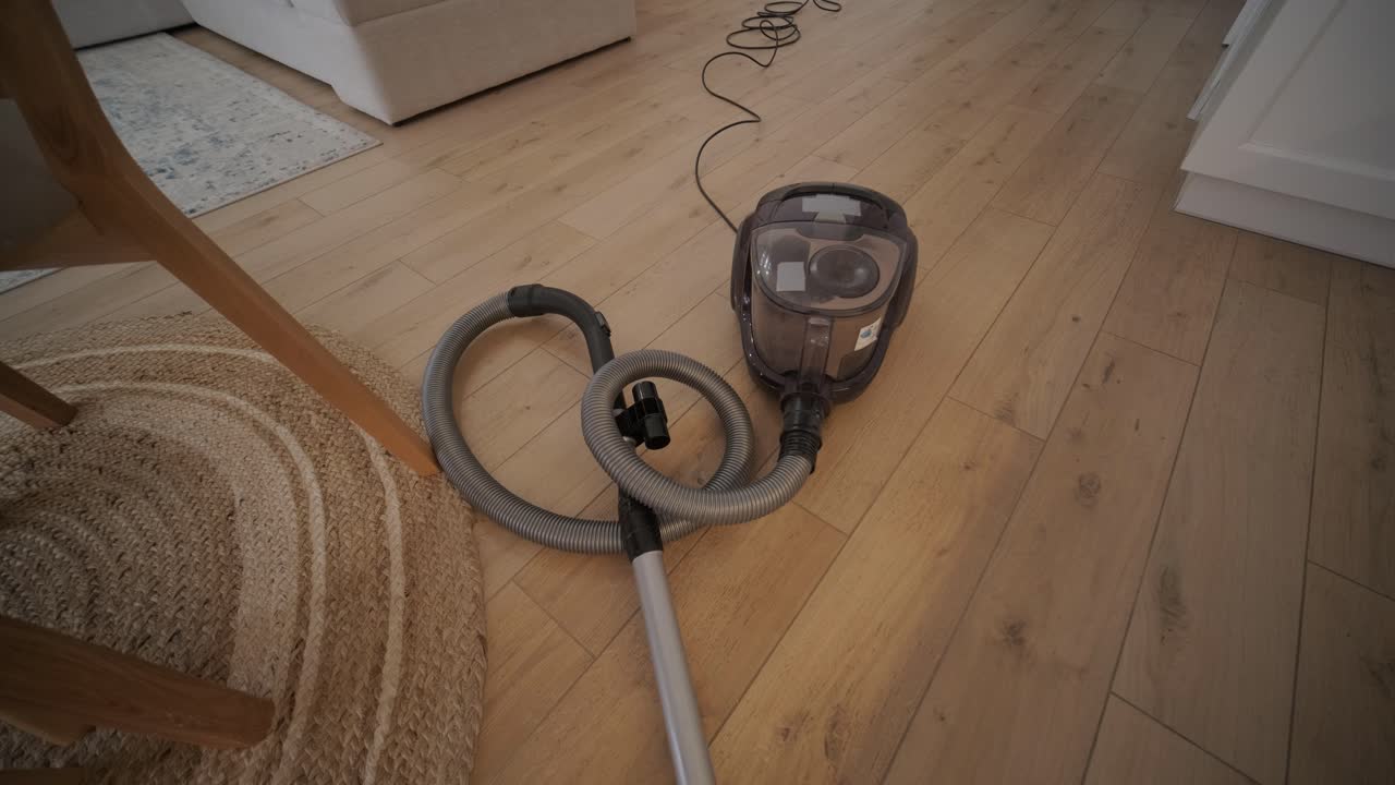 Vacuum Cleaner Running on a Wooden Floor in a Modern Home