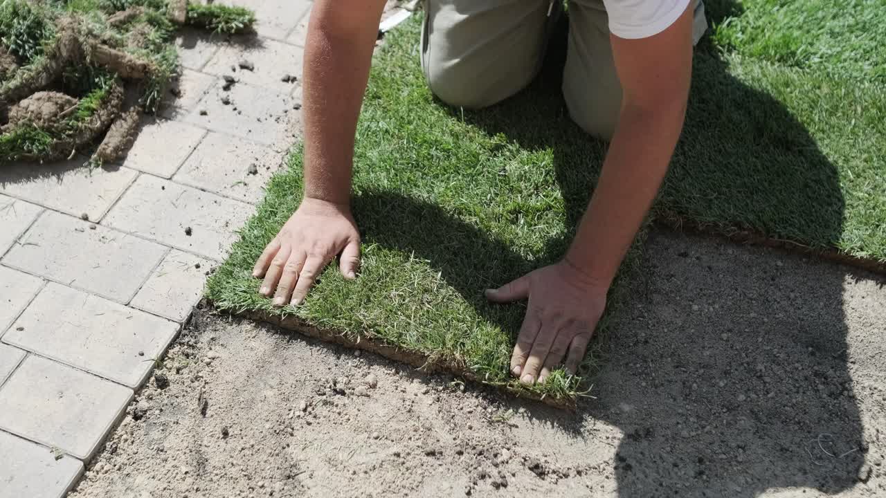 hombre colocando césped en el jardín del patio trasero para la instalación de césped y proyecto de jardinería, centrado en la mejora del hogar y el mantenimiento al aire libre para un césped fresco y verde en un patio residencial