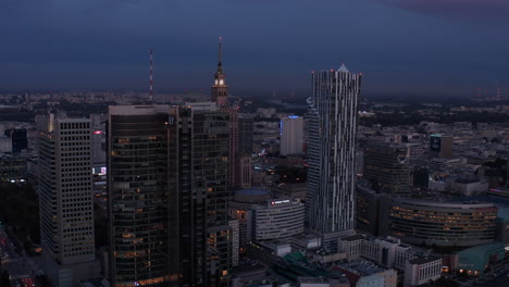 Abendliche-Dia--Und-Schwenkaufnahmen-Von-Wolkenkratzern-In-Der-Innenstadt.-Enthüllender-Historischer-Kultur--Und-Wissenschaftspalast-Im-Russischen-Stil-Zwischen-Modernen-Gebäuden.-Warschau,-Polen