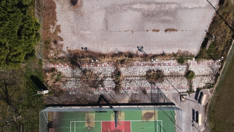 panning aerial overhead drone clip over a basketball court in choristi village, drama, greece