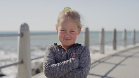 portrait little blonde girl looking angry arms crossed naughty cacuasian kid on sunny seaside beach background