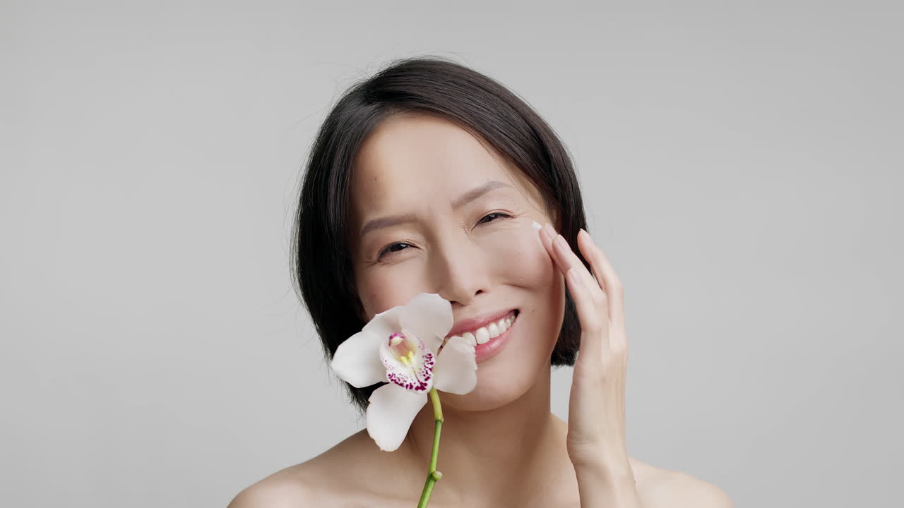 Happy Woman with Orchid and Skincare