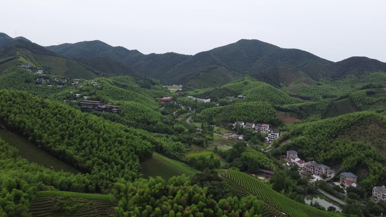 Aerial View of a Serene Village nestled in Lush Green Mountains