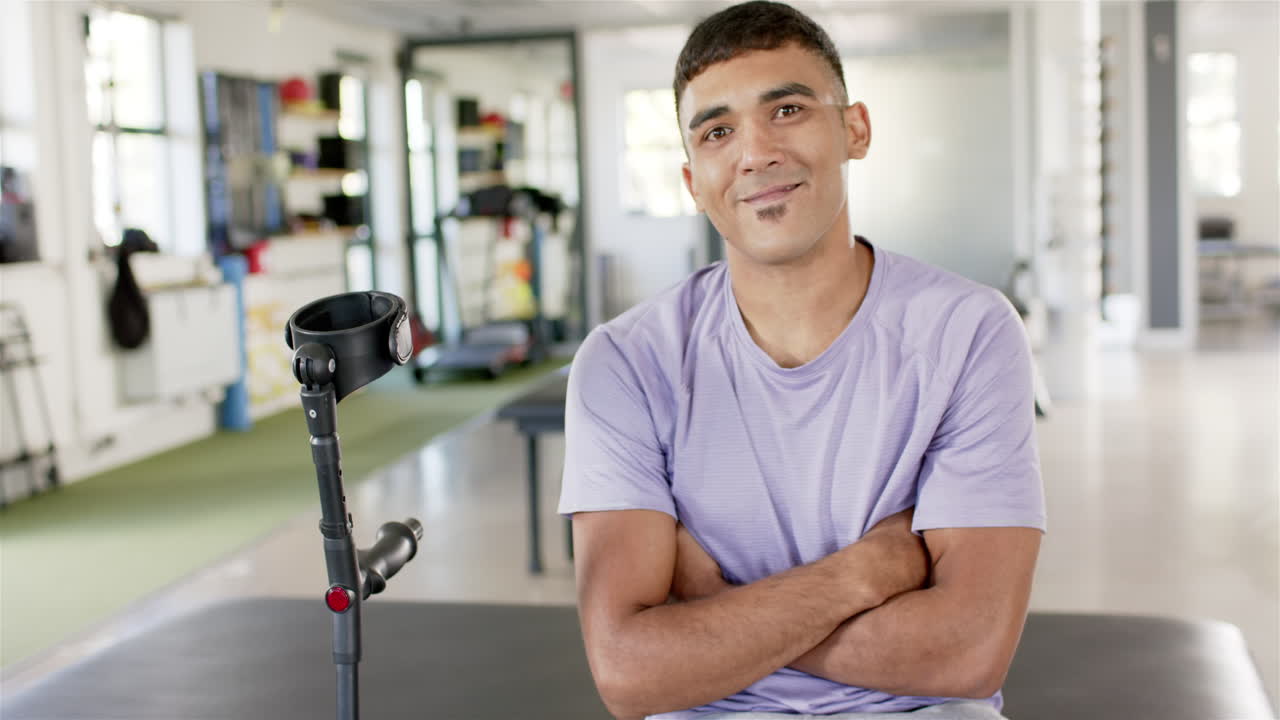Man with crutches sitting in rehabilitation center, smiling confidently