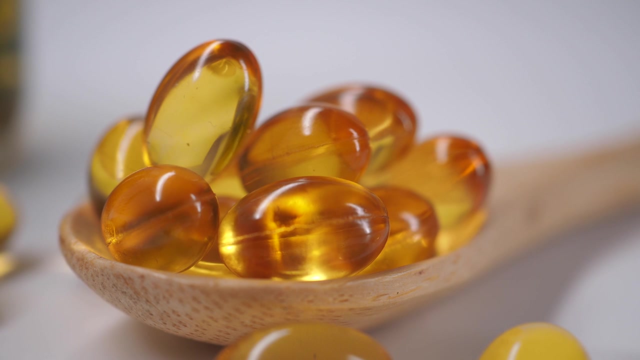 Kapsul Minyak Ikan Omega-3 Emas di Atas Sendok Kayu