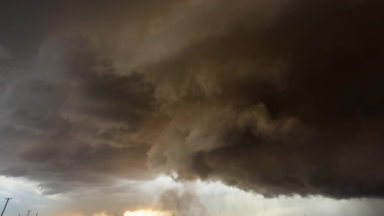 Awan gelap pekat yang mengancam bergerak di langit badai yang intens sebagai latar belakang cuaca.