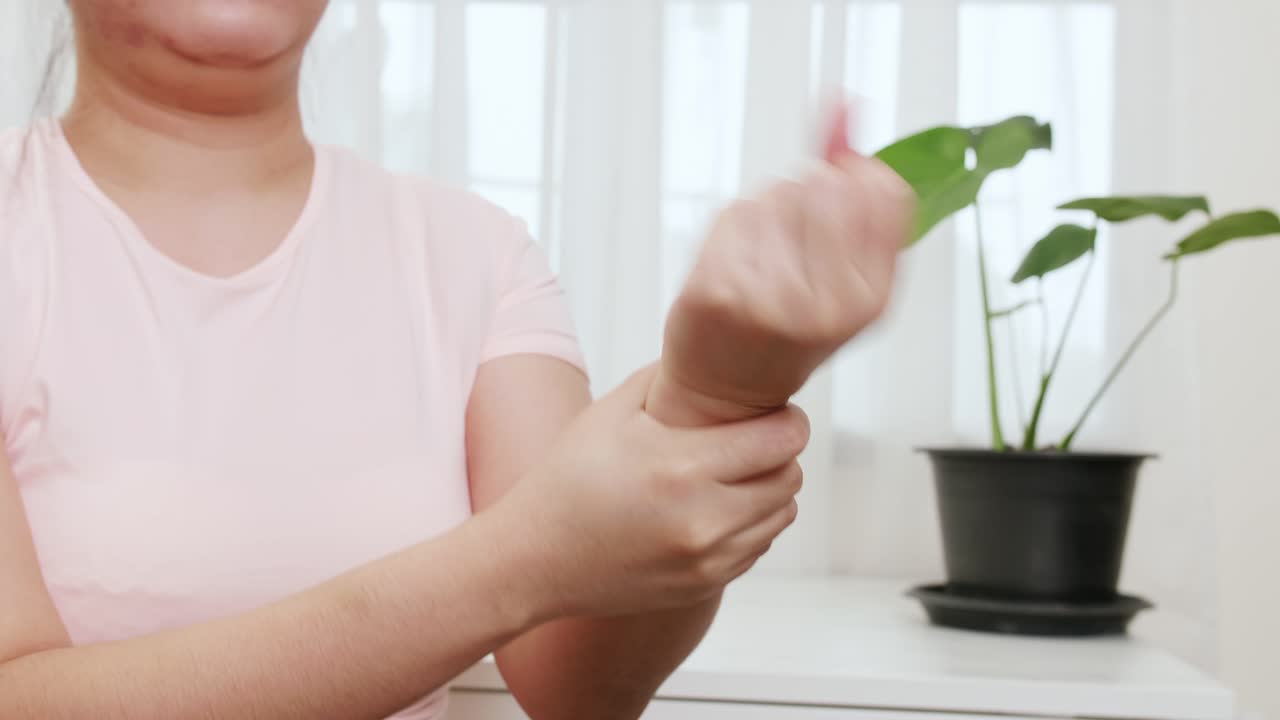 아시아 여성들은 업무 관련 통증과 통증을 줄이기 위해 물리 치료에서 손목을 돌리고 손목을 흔들고 있습니다.