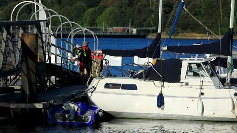 two men on the saltash pontoon with their boats on the river tamar between devon and cornwall