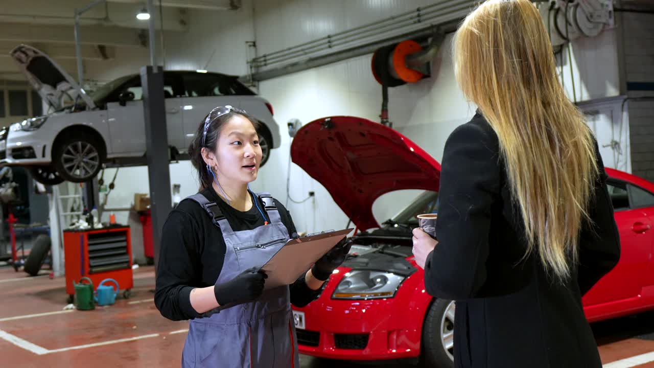 Mechanic discussing car repairs with customer in auto repair shop