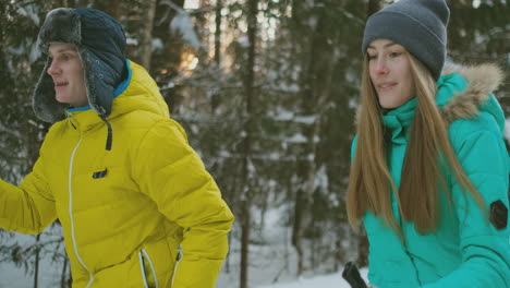 a married couple is skiing in the forest practicing a healthy lifestyle. slow motion