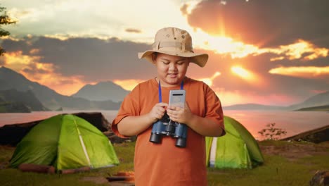 happy child exploring nature with smartphone and binoculars