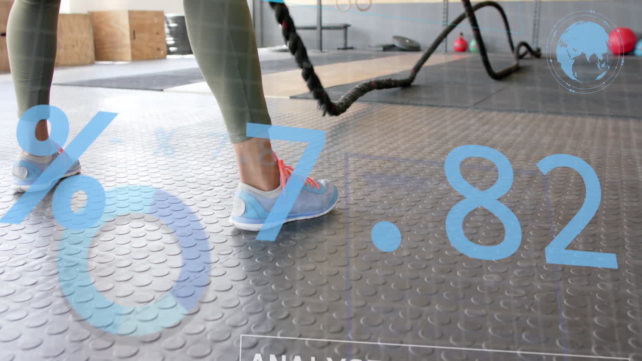 Animazione di un'interfaccia che elabora dati sui piedi di una donna caucasica che si allena con le battle ropes in palestra