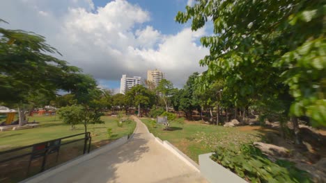 aerial fpv drone flying through trees of mirador sur park in santo domingo