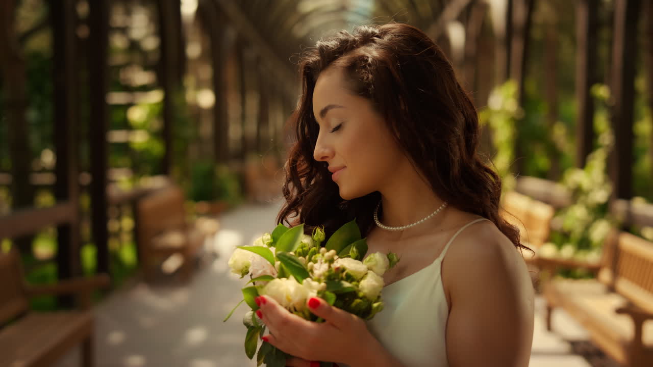 Beautiful woman smelling flowers in garden