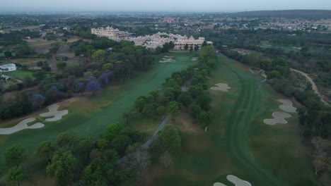 Aerial drone shot showcasing a stunning view of a golf course in Delhi, with golfers playing amidst the scenic greenery.