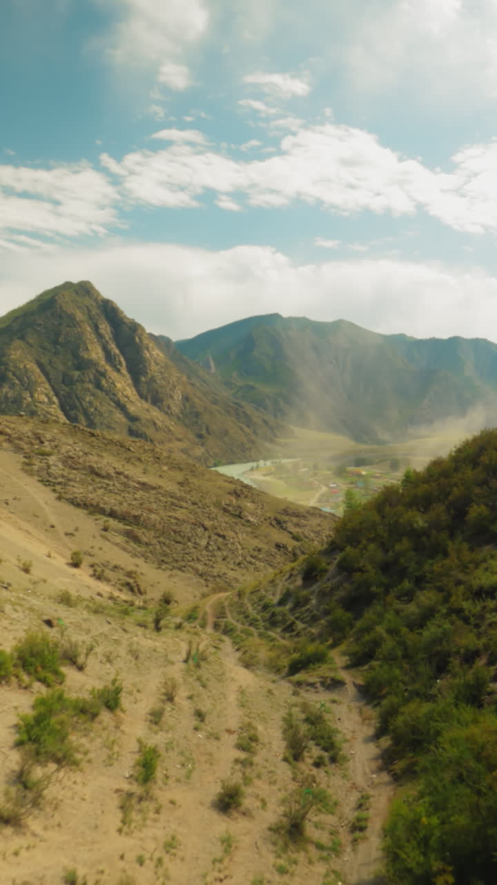 Chasm carves divide between mountains fpv. Dense forest with trails etched upon slopes creating scene of stark natural beauty. Picturesque landscape