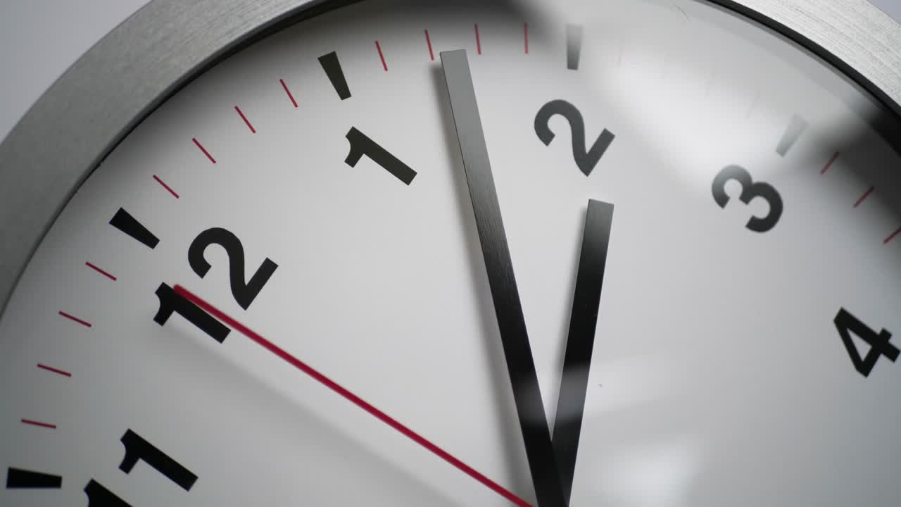 Close up of a ticking clock on white background, window reflection