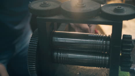 jeweler-forge-rolls-gold-with-machine-at-workplace-closeup