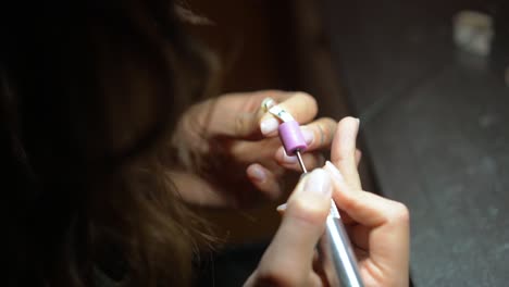 mujer trabajando con herramientas de precisión en un objeto pequeño