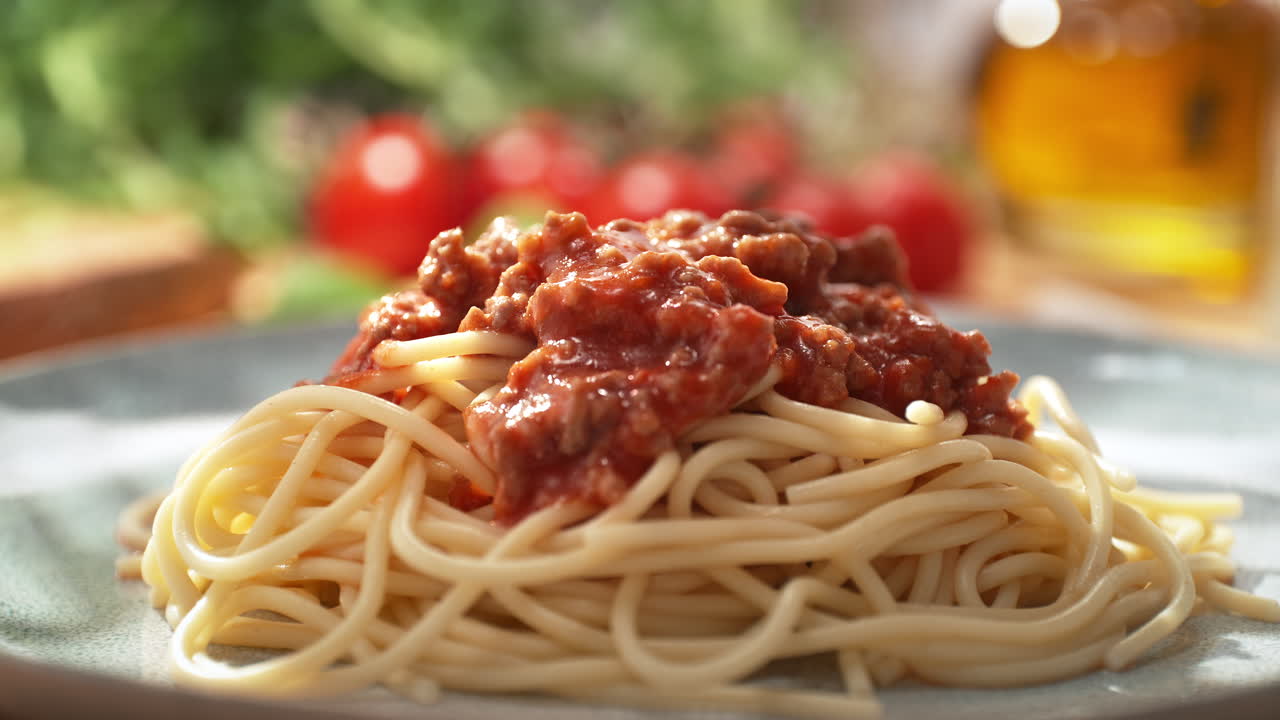 파스타 요리에 고기와 함께 토마토 소스를 부어 - 밝은 접시에 제공 된 스파게티 볼로네즈, 돌리 아웃, 느린 모션