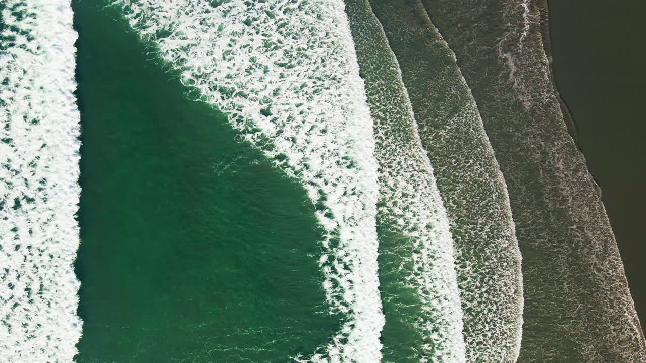 Drone flying over waves that are flushing into the beach