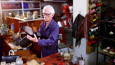 shoemaker examining a shoe