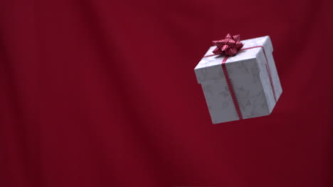 christmas present thrown into the air red background