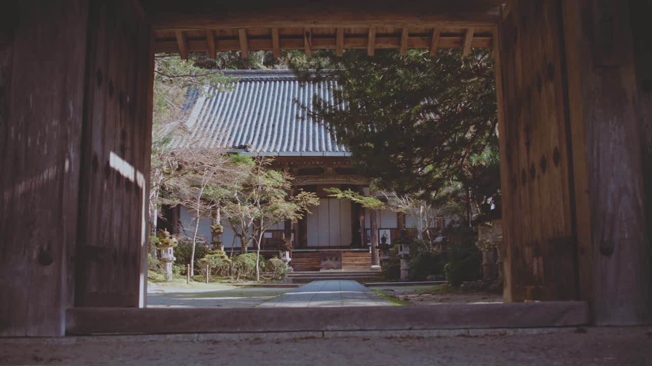 View of Takaosan Temple in Japan, captured with a monk walking in the peaceful background, evoking a sense of spirituality and calm.