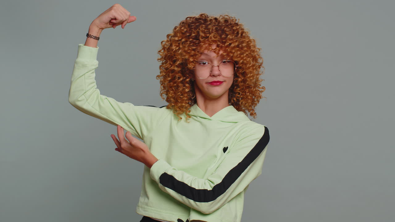 niña en forma, niña deportiva, niña que muestra bíceps y se ve saludable, siente poder, fuerza, éxito, victoria.