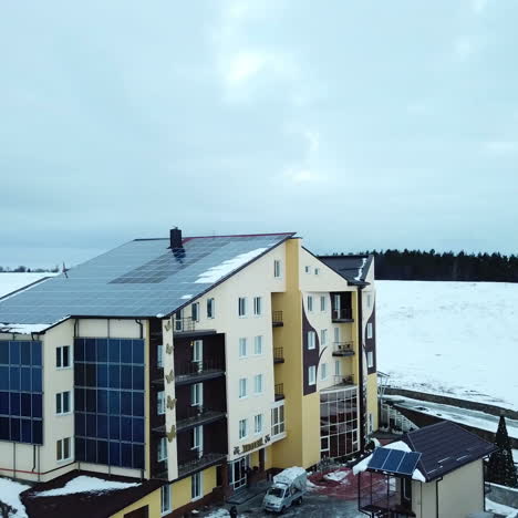 hotel complex in the mountains with solar panels on the snow. rows of snow covered solar panels in a small solar power plant.