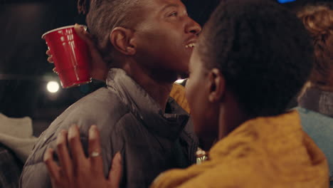 happy-african-american-couple-kissing-having-fun-dancing-in-rain-enjoying-lively-rooftop-party-celebration-at-night