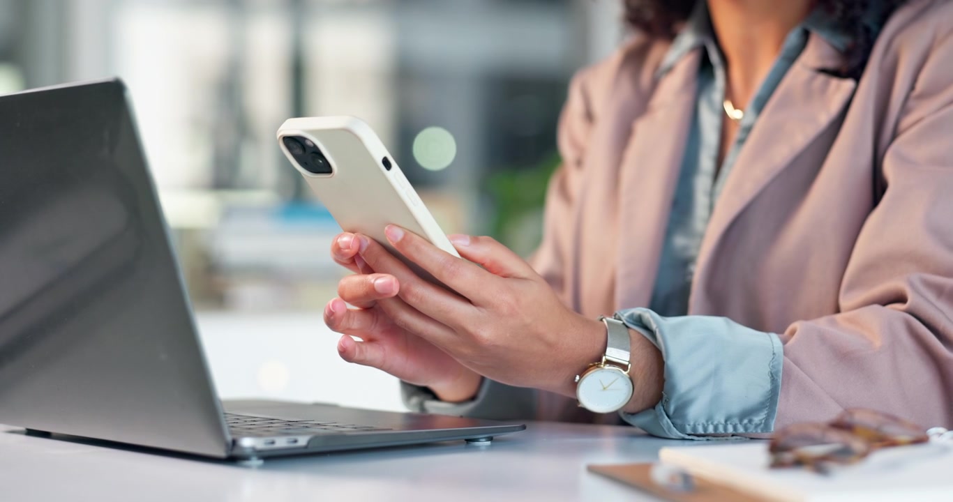 donna professionista che usa lo smartphone alla scrivania del suo ufficio