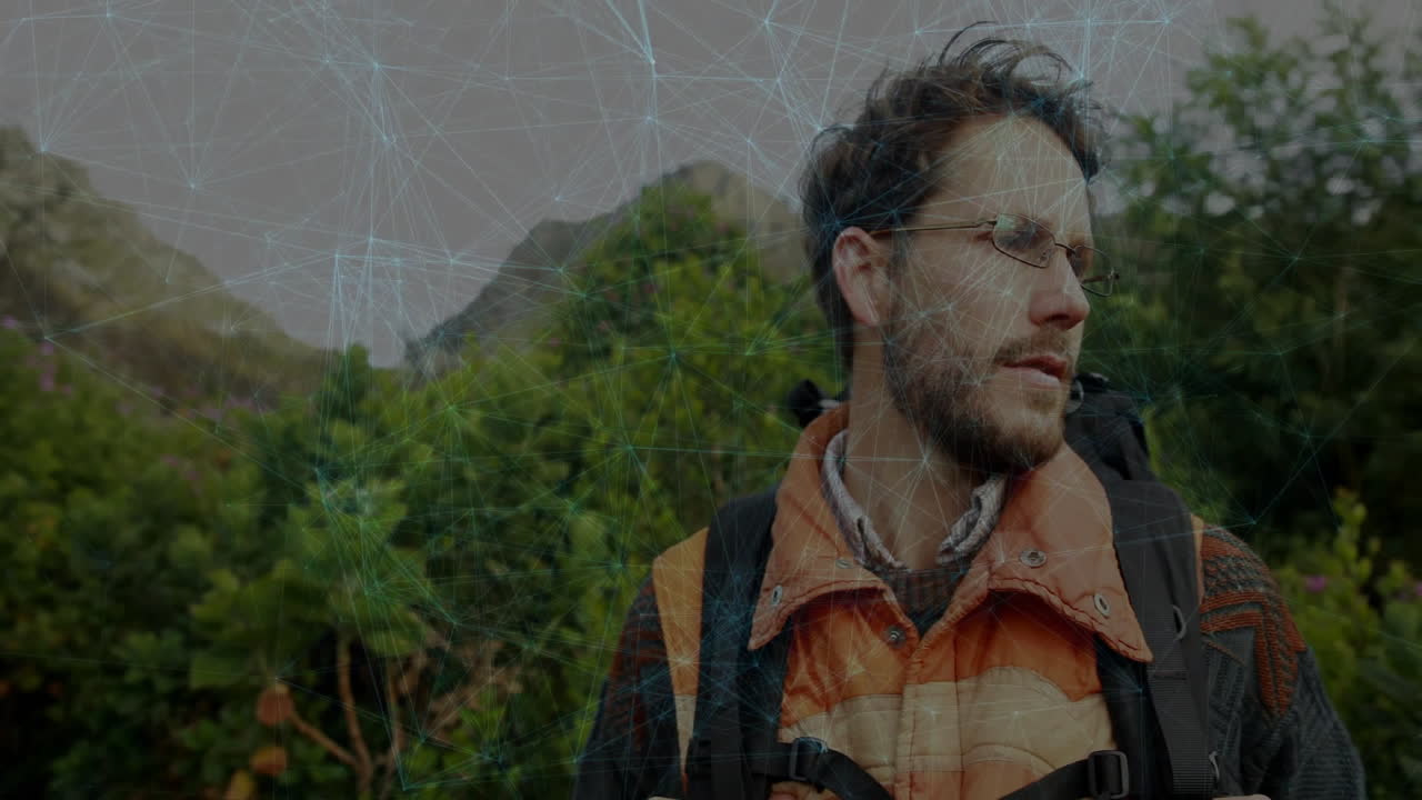 man hiking on hillside trail, carrying backpack, showing network graphic overlay for technology